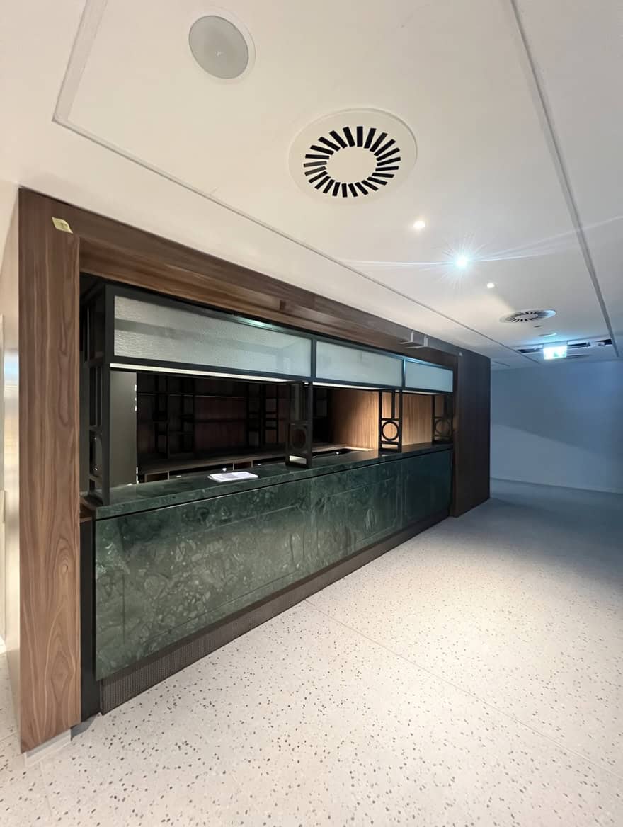 Blackened steel back-bar framework with illuminated shelving at Everton Stadium hospitality area