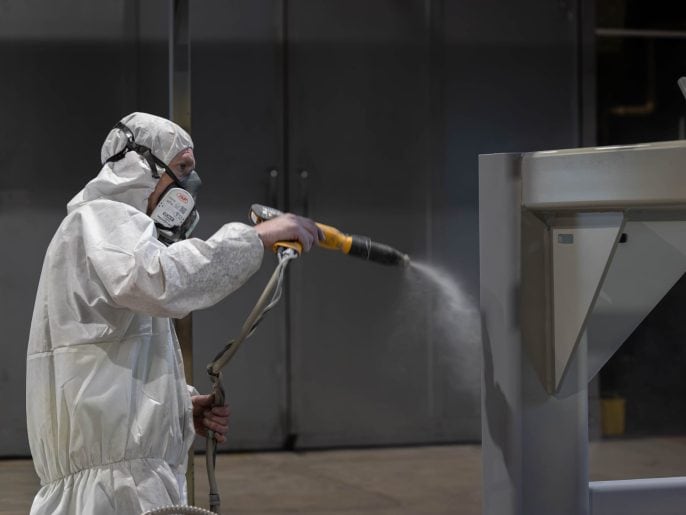 Powder coating a steel frame in MorFab's in-house powder coating booth